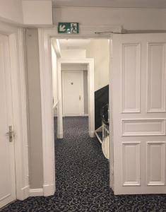 a view of a hallway with a white door at City Hotel - HEEFA OHG in Hamburg