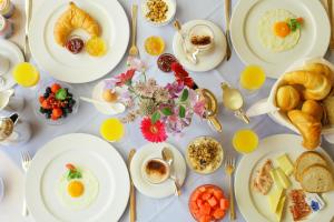 a table with plates of breakfast food on it at Petit Steffani Bed & Breakfast in St. Moritz