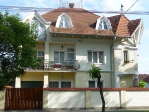 a white house with a red roof at Apartmanház Sipos Siófok in Siófok