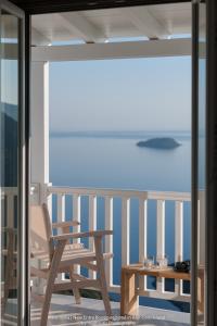 a rocking chair and a table on a balcony at Althea Traditional Hotel in Alonnisos