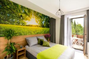 クリニツァ・ズドルイにあるELuxuria GREEN HlLL Apartment przy stoku narciarskim OZONOWANYの緑の壁画が施されたベッドルーム