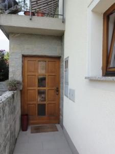 een houten deur aan de zijkant van een gebouw bij Apartma Jezero in Most na Soči