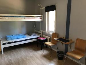 ヴィスビーにあるSTF ホステル ヴィスビー / レヴハーゲンの小さなお部屋で、二段ベッド1組、椅子2脚が備わります。