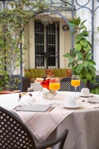 stół z dwoma kieliszkami soku pomarańczowego na nim w obiekcie Villa Imperiale Hotel w mieście Spotorno