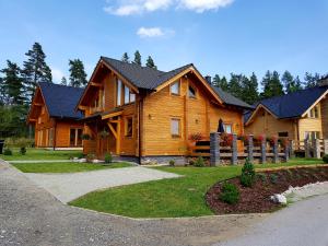 ein großes Holzhaus mit einem Weg davor in der Unterkunft Chata Nikol in Tatranská Lomnica