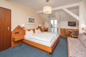 ein Hotelzimmer mit einem Bett und einem Schreibtisch in der Unterkunft Seehotel Grauer Bär in Kochel