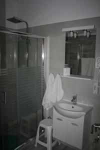 a bathroom with a sink and a glass shower at Emily's Apartments in Kassiopi +41 photos