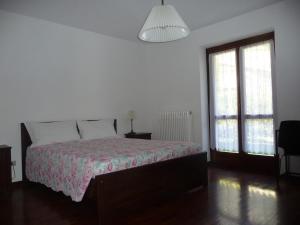 a bedroom with a bed and two windows at Maison Borbey in Aosta