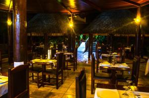 an empty restaurant with tables and chairs and tablesearcher at Long Beach in Canoa Quebrada