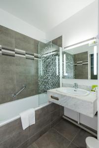 a bathroom with a sink and a shower at Logis Hotel Le Relais de Comodoliac in Saint-Junien