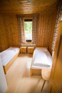 ゴーザウにあるJugendgästehaus Gosauschmiedのベッド2台と窓が備わる客室です。