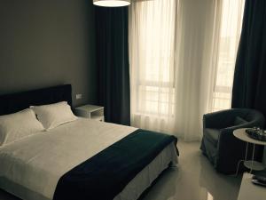 a bedroom with a bed and a chair and window at Mamaia Beach Side in Mamaia