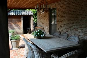 Une table et des chaises en bois sont disponibles sur la terrasse. dans l'établissement Under Oaks, à Westmalle
