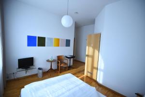 a bedroom with a bed and a tv in it at Art-Hotel Robert Mayer in Frankfurt