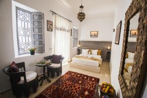 a bedroom with a bed and a table and a chair at Riad De Vinci & SPA in Marrakesh