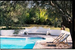 a pool with two chairs and a bench next to it at Horta de Torrejais in Moura
