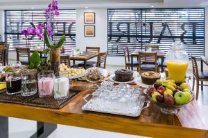a table with food and drinks on top of it at Bauru Office Hotel in Bauru +21 photos
