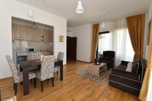 ein Wohnzimmer und eine Küche mit einem Tisch und Stühlen in der Unterkunft Lux Apartments Kristina in Budva