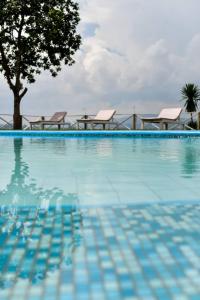 uma piscina com água azul e uma árvore em Pili Pili Boutique Hotel em Kigali