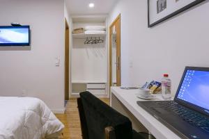 a laptop computer sitting on a desk in a bedroom at Bauru Office Hotel in Bauru