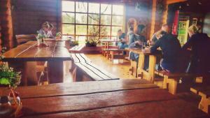 a group of people sitting at tables in a restaurant at Pas Medžiotoją Motelis in Kryžkalnis