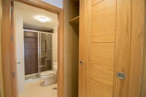 マラガにあるConMdeMálaga San Quintinのバスルーム(トイレ付)、木製のドアが備わります。