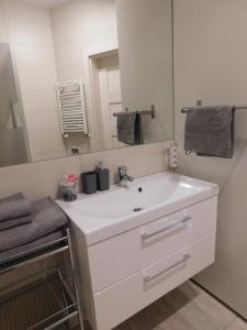 a bathroom with a white sink and a mirror at Apartament Pogodny in Łeba +31 photos