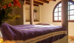 a bed with a purple blanket on top of it at Heven B&B in Zipolite