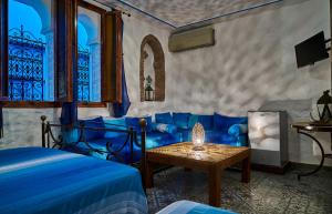 Un dormitorio con una cama azul y una mesa. en Dar Yakout, en Chefchaouen