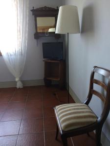 a room with a chair and a lamp and a television at La casina del Poggio in Ponticino