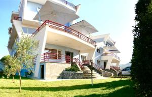 a white building with stairs and umbrellas on it at Diamond Beach Residence Hotel in Durrës