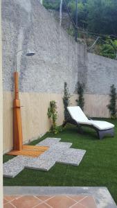 a garden with a bench and a chair on the grass at Casa Rosanna in Maiori