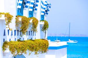 un edificio bianco con dei fiori sopra, vicino all'acqua di AVANTI Lifestyle Hotel - Only Adults a Corralejo