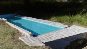 a blue swimming pool with a set of steps around it at La Cartuja de Cazalla in Cazalla de la Sierra