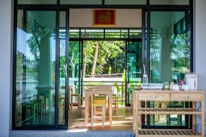een restaurant met glazen deuren en een tafel en stoelen bij Wanarom Residence Hotel in Krabi town