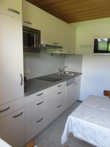 kuchnia z białymi szafkami, zlewem i stołem w obiekcie Haus Buchsteiner w mieście Radstadt