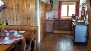 cocina con suelo de madera y mesa de madera con sidra de mesa en Sommeralmhütte en Sankt Kathrein am Offenegg
