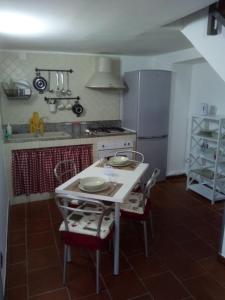 ナポリにあるNapulè Apartmentのキッチン(白いテーブル、冷蔵庫付)