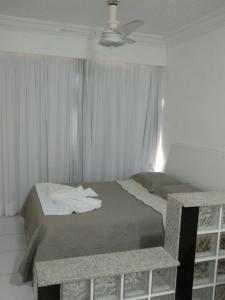 1 dormitorio con 1 cama y ventilador de techo en Flat Avenida Oceânica Barra, en Salvador