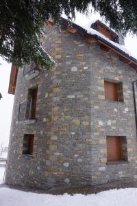 a stone building with windows and snow on it at Apartamento Bachimala in Huesca