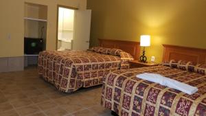 una camera d'albergo con due letti e una lampada di Luxury Inn ad Absecon