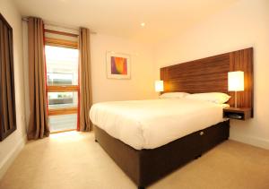 - une chambre avec un grand lit et une fenêtre dans l'établissement PREMIER SUITES Bristol Cabot, à Bristol
