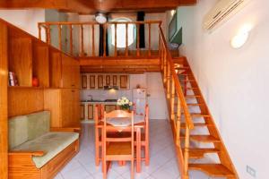 a staircase in a room with a table and a kitchen at Holiday ApartHotel in Santa Maria