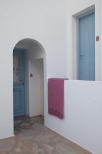 a hallway with two doors and a purple towel on a wall at Oliaros seaside complex in Agios Georgios