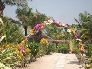 a pathway with a bunch of flowers on it at Bolongs Passion in Cap Skirring +14 photos