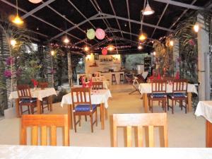 une salle à manger avec des tables et des chaises ainsi qu'un restaurant dans l'établissement Bolongs Passion, à Cap Skirring