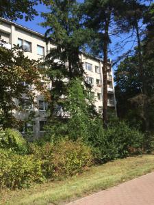 un edificio de apartamentos con árboles y arbustos delante de él en Art residence Jurmala, en Jūrmala