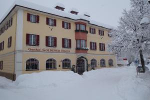 a building with snow in front of it at Gasthof Goldener Fisch in Lienz