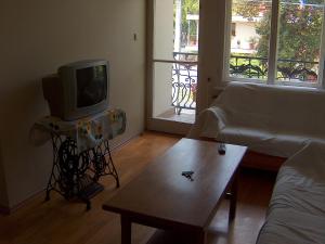 a living room with a tv and a coffee table at Apartmanház Sipos Siófok in Siófok