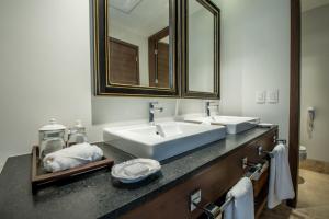 łazienka z 2 umywalkami i dużym lustrem w obiekcie Square Small Luxury Hotel - Providencia w mieście Guadalajara
